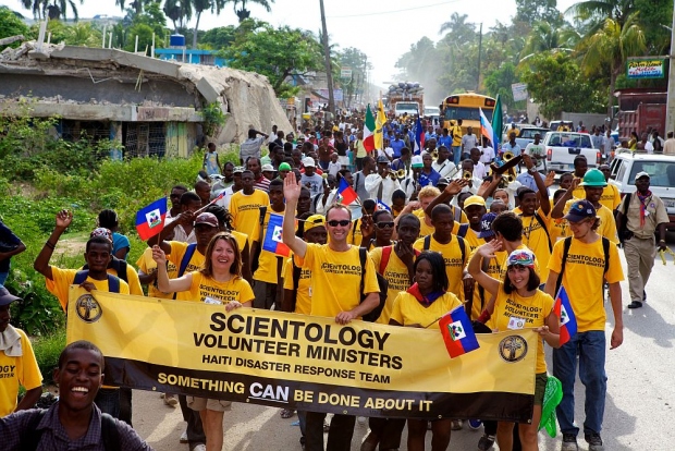 יועצים רוחניים מתנדבים של סיינטולוגיה מהאיטי ומארצות אחרות צועדים מקרפור שבפרברי פורט-או-פרינס אל העיר לאוגן בחגיגת יום הדגל, חג לאומי לזכר עצמאותה של האיטי מהכיבוש הצרפתי ומהעבדות ב-1803.